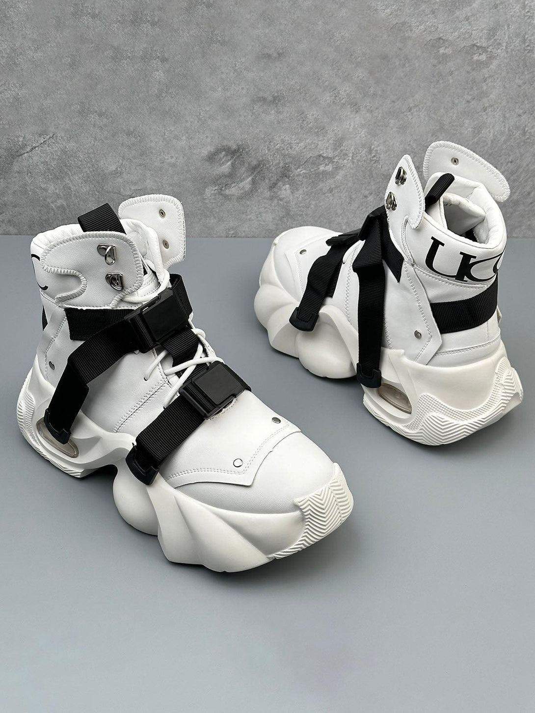 White dual-strap runner boots by TALISHKO, featuring a bold, futuristic design with unique soles.