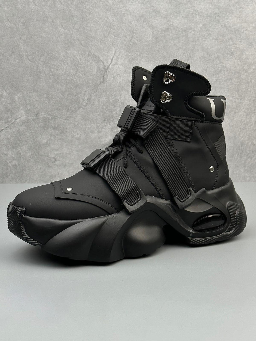 Futuristic black runner boots by TALISHKO, featuring a unique dual-strap design and bold silhouette.