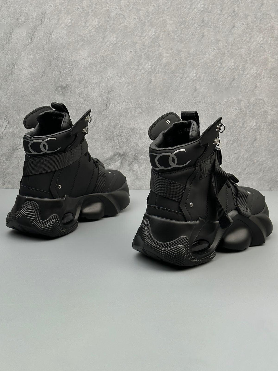 Back view of black dual-strap runner boots by TALISHKO, highlighting futuristic details.
