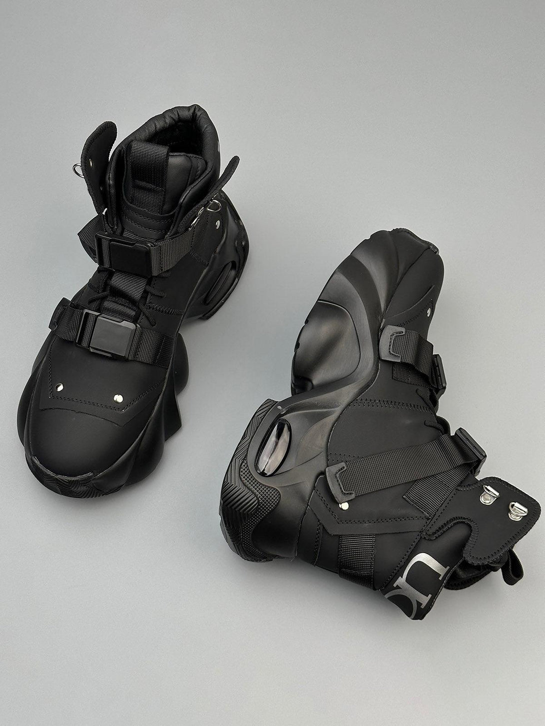 Futuristic black dual-strap boots by TALISHKO, highlighting sleek design and unique details.