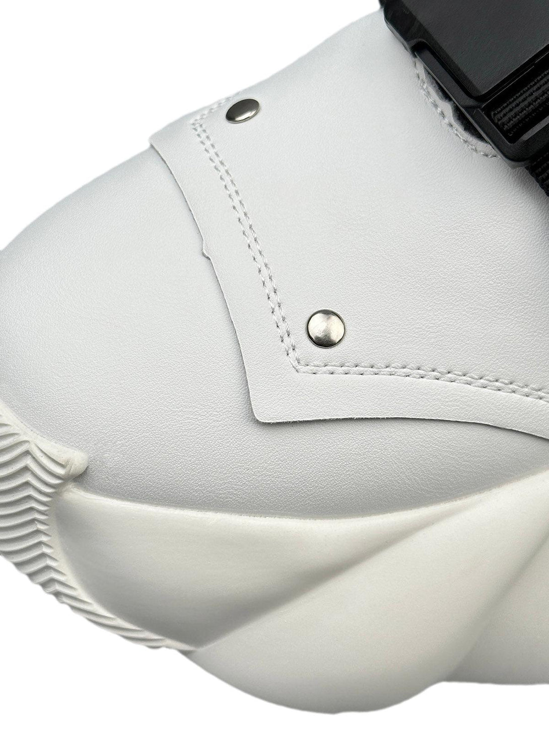 Focusing on the sleek details of TALISHKO's white dual-strap runner boots with unique stitching.