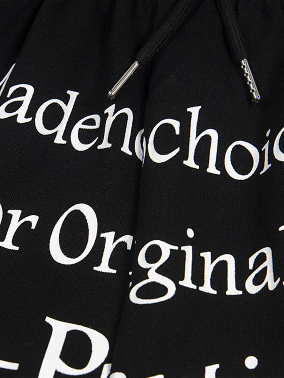 A close-up of TALISHKO black shorts highlighting bold white lettering and drawstring details.