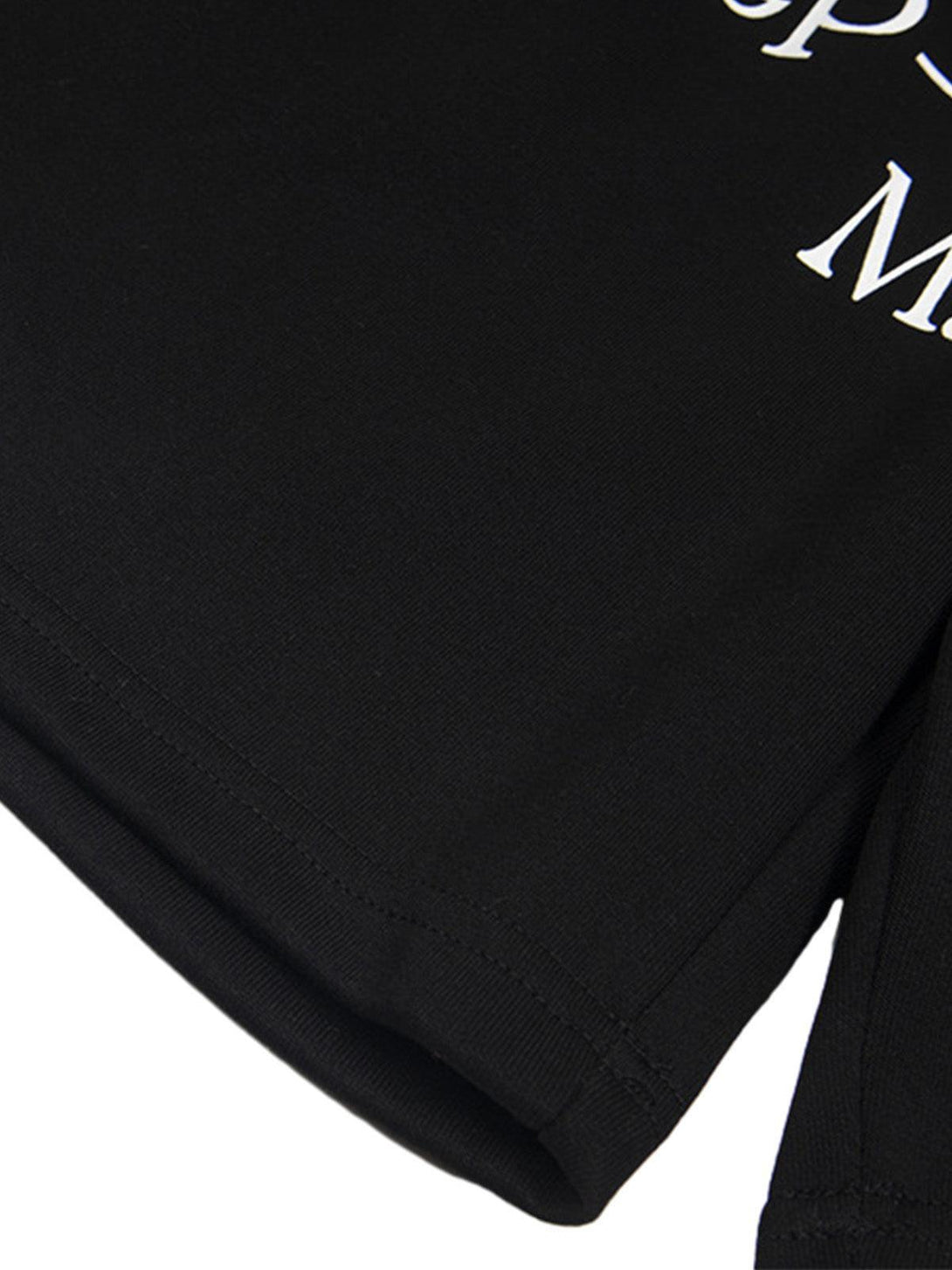 A detailed view of TALISHKO's black shorts, highlighting the intricate white lettering design.