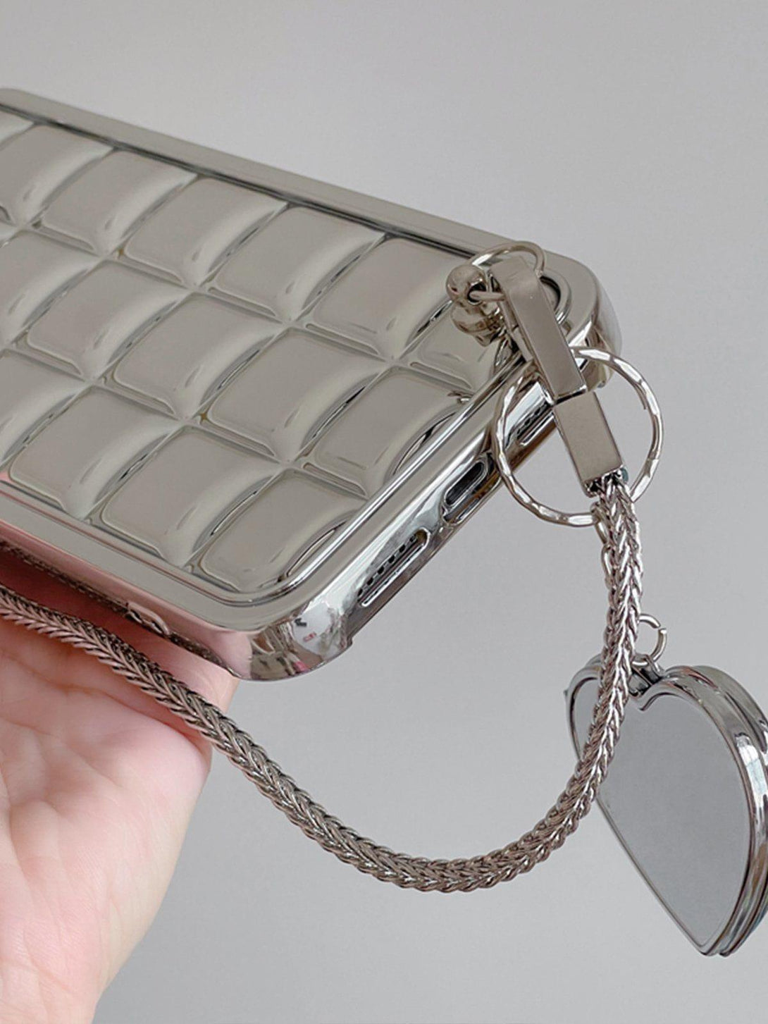 A shiny mobile phone case with a heart chain by TALISHKO, featuring an electroplate block pattern.