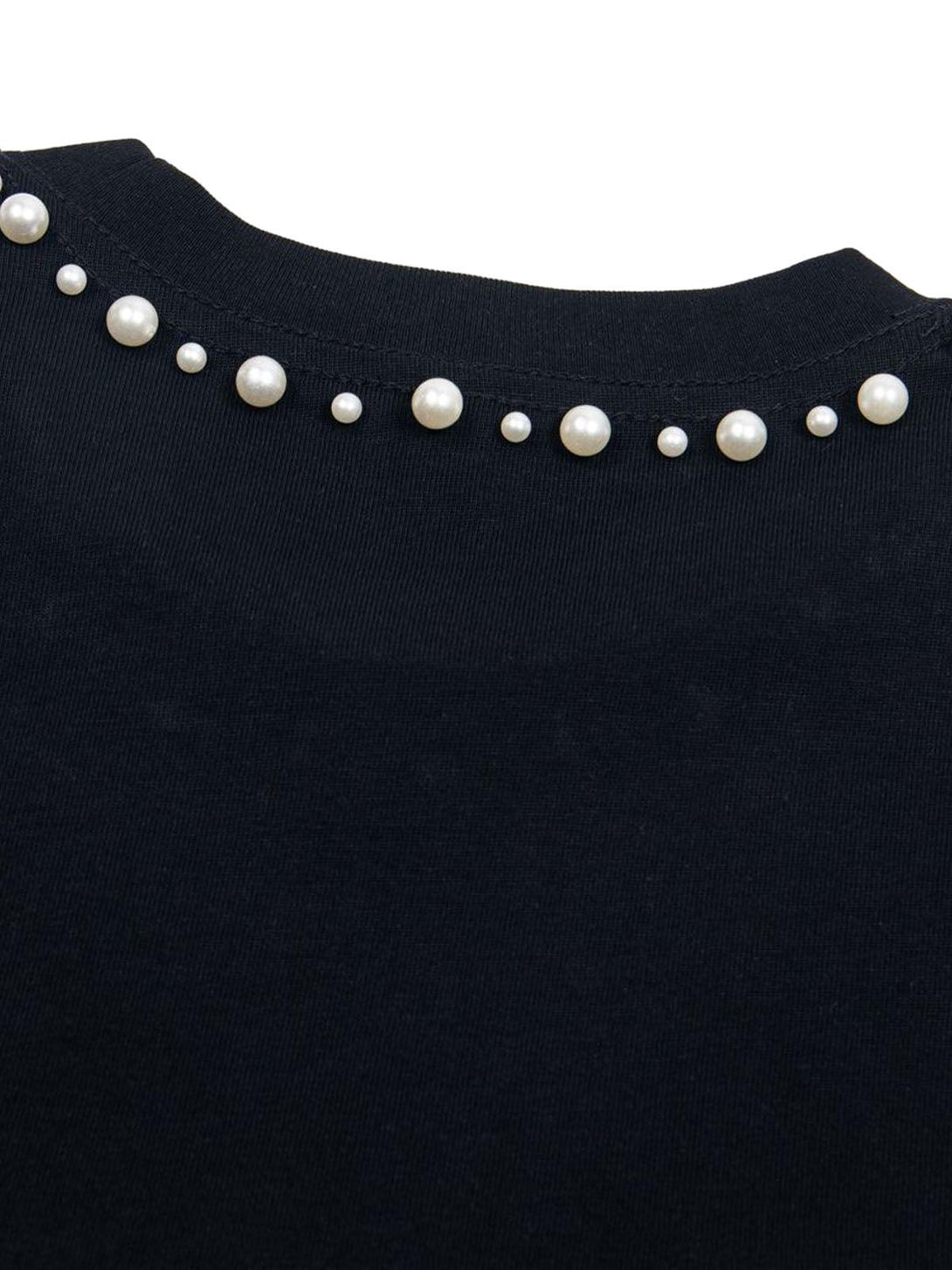 Pearl detail on a black oversized T-shirt by TALISHKO, highlighting chic design elements.