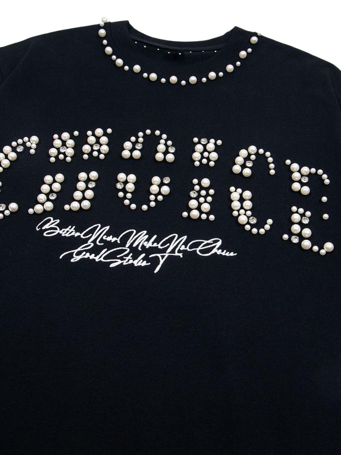 Close-up of pearl embellishments on a black oversized T-shirt by TALISHKO, perfect for casual wear.