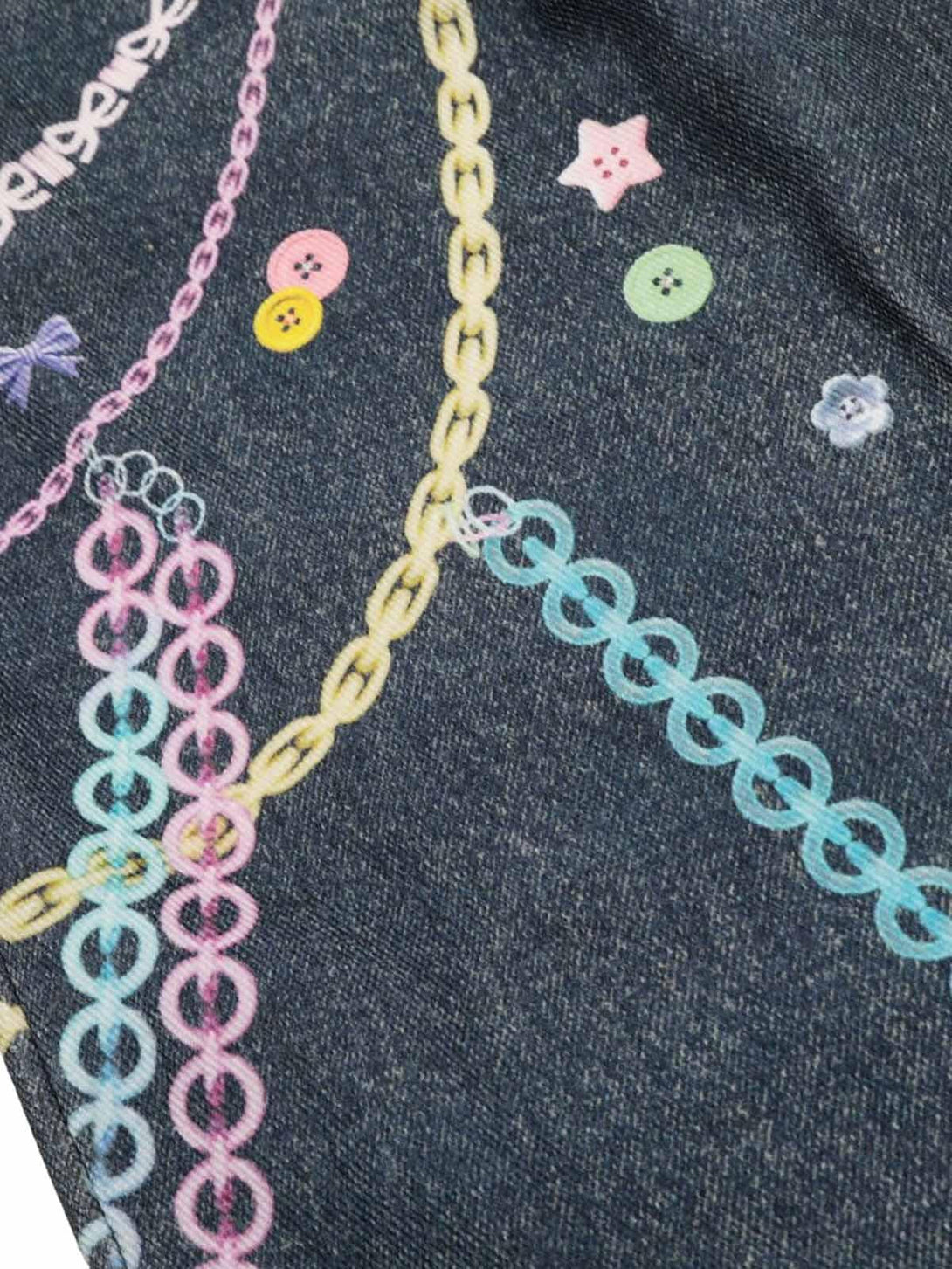 Intricate design detail from TALISHKO denim, featuring playful chain and button patterns.