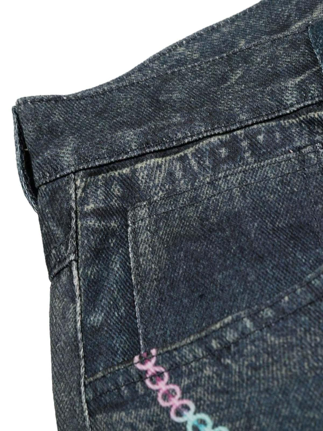 Focusing on the detailed stitching and colorful chain embellishments on TALISHKO denim shorts.