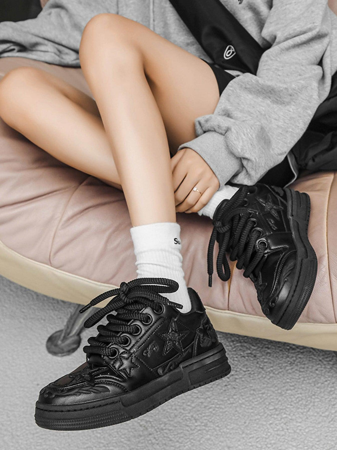 TALISHKO's embossed star board shoes in black, worn with a cozy gray hoodie for a casual vibe.