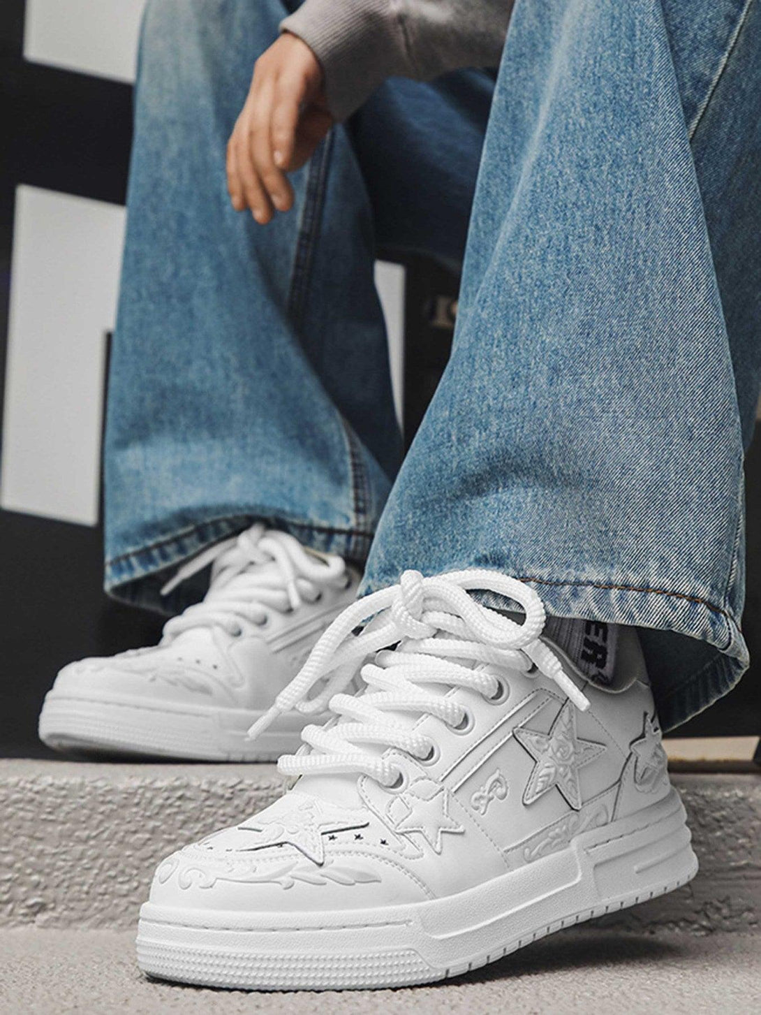 TALISHKO's white embossed star board shoes paired with relaxed denim for a casual street style.