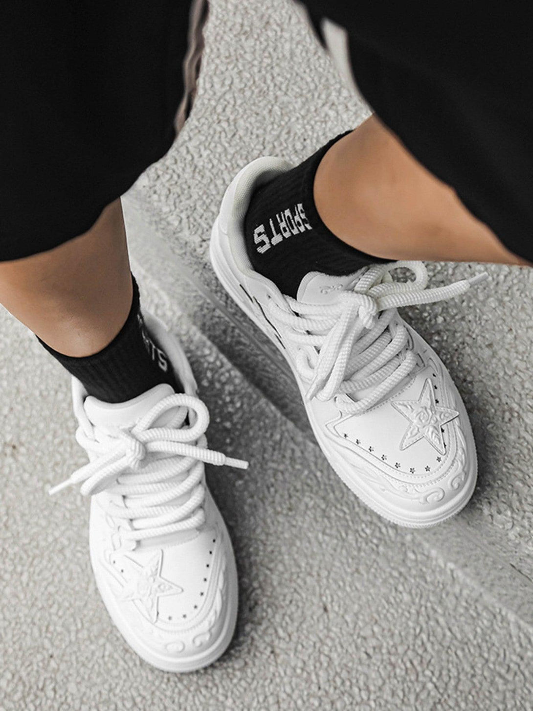 White embossed star board shoes by TALISHKO, paired stylishly with black sports socks.
