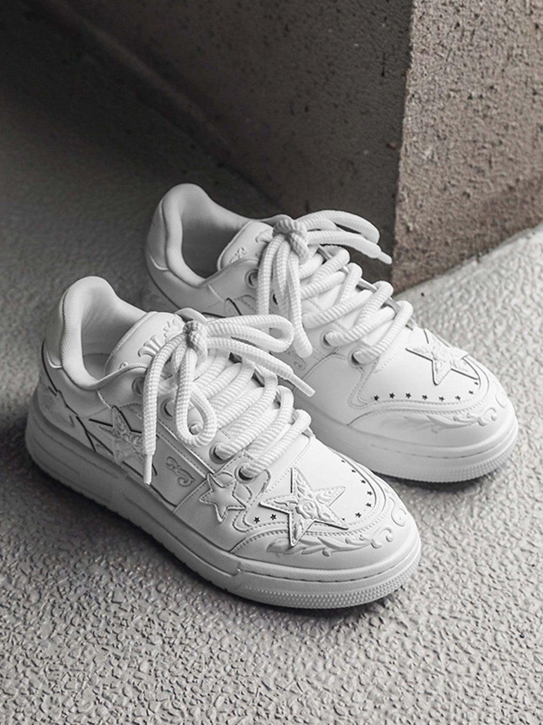 TALISHKO's white casual board shoes with embossed stars, highlighting a unique textured design.