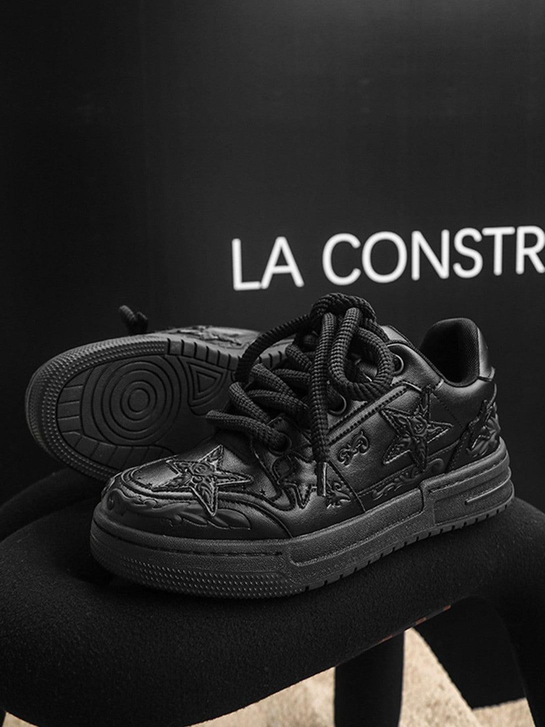 Black embossed star casual board shoes by TALISHKO, highlighting intricate design details.