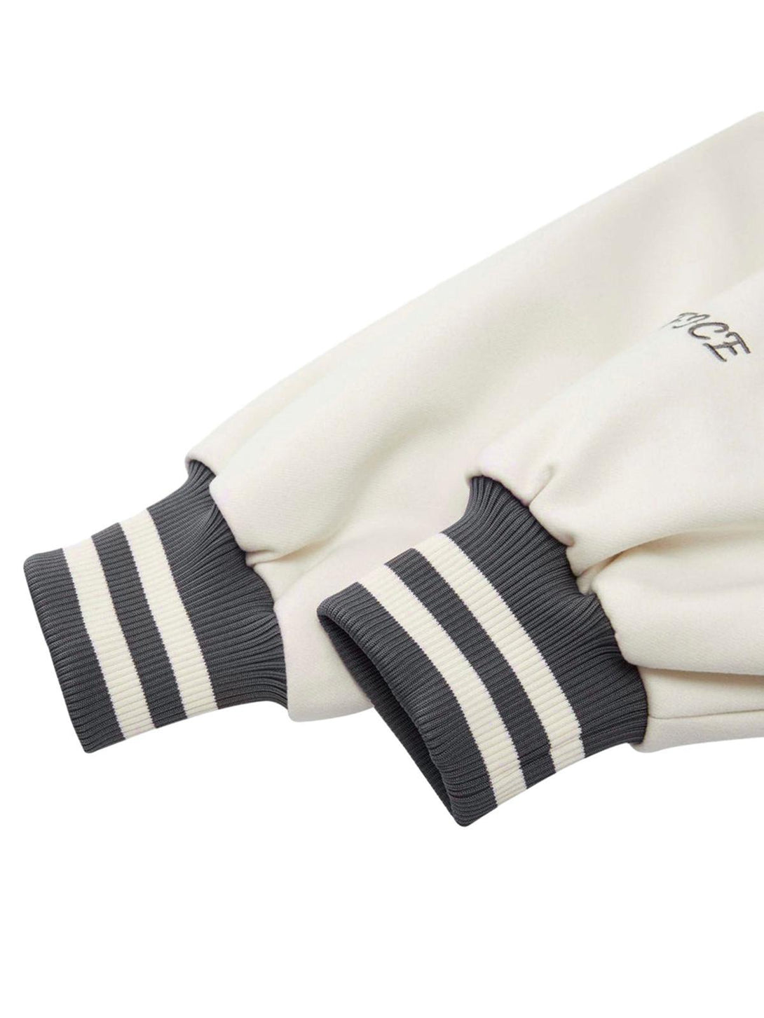 A close-up of the TALISHKO embroidered baseball bomber jacket's striped cuffs and sleeve detail.