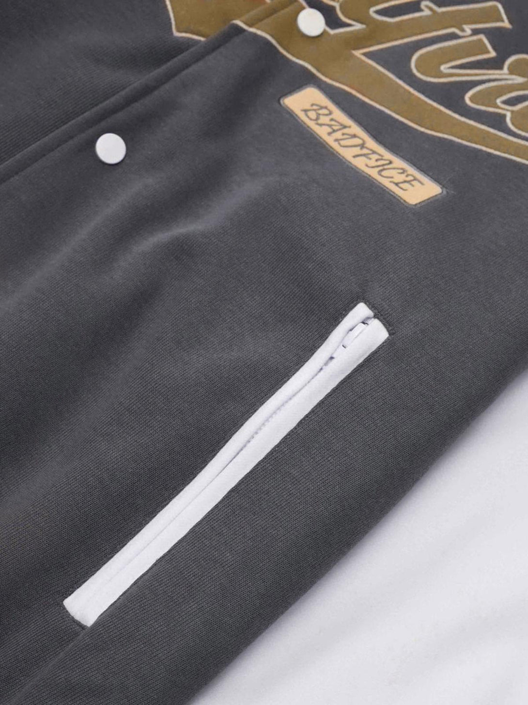 A detailed view of the TALISHKO embroidered baseball bomber jacket's sleek pocket design.