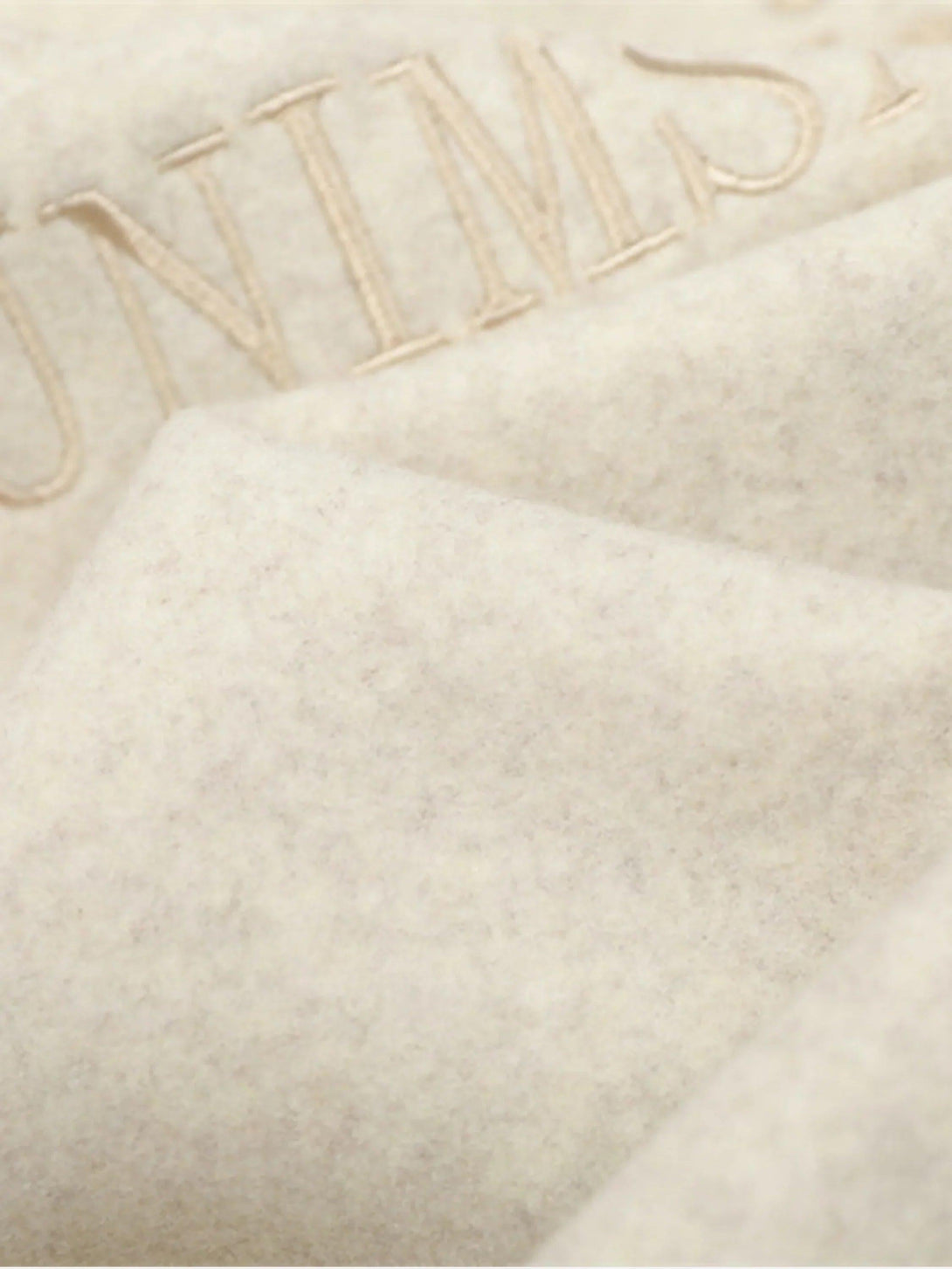 Intricate look at TALISHKO varsity jacket fabric, highlighting embroidered detail and texture.