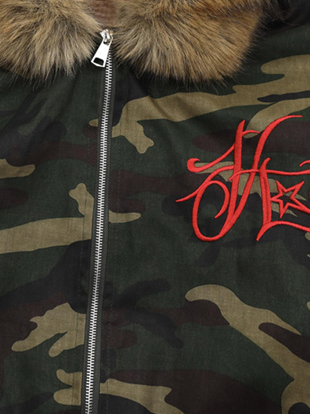Detailed fabric and embroidery on camo jacket, featuring TALISHKO's detachable fur hood.