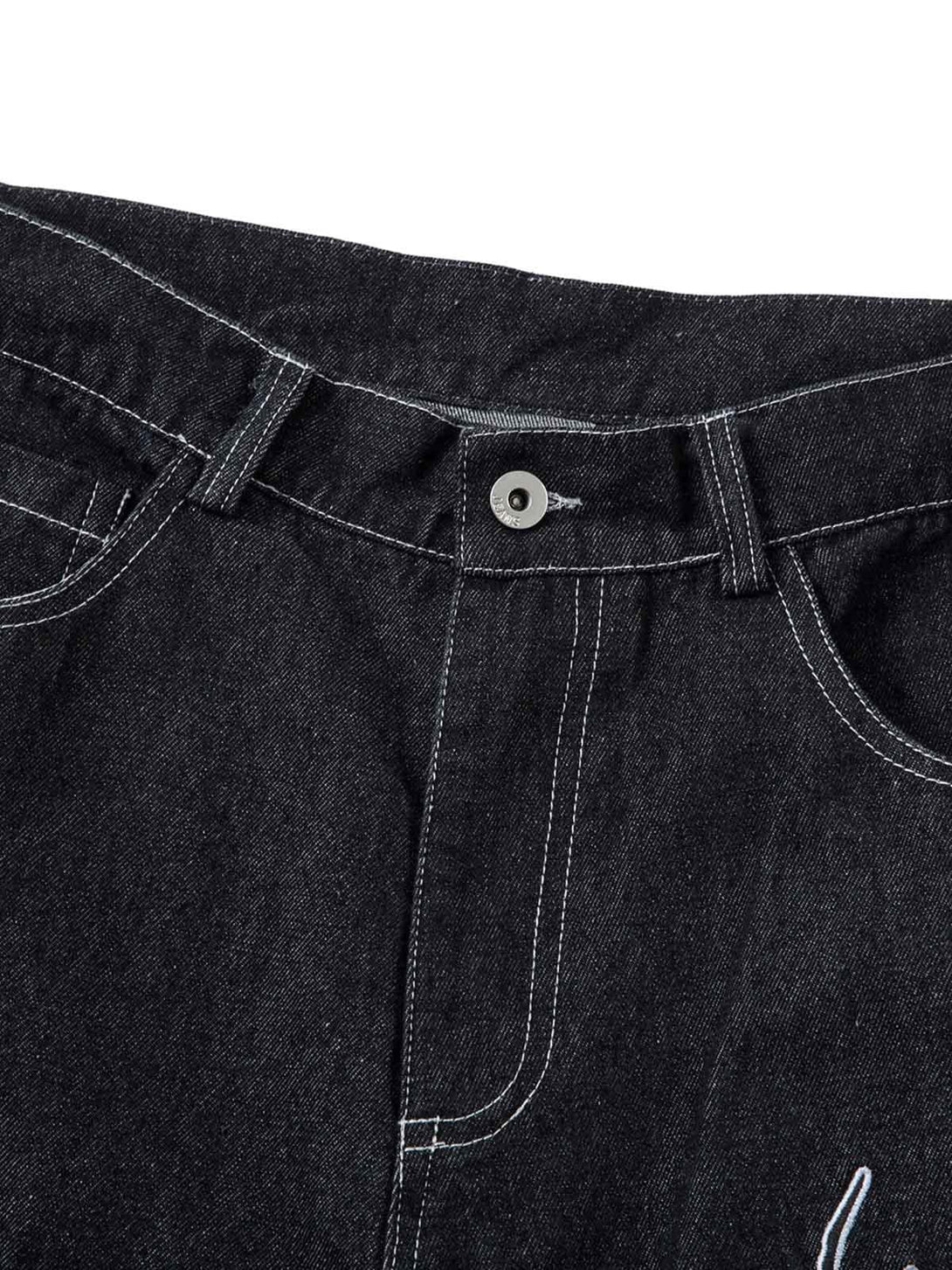 Detailed view of the waistband and stitching on TALISHKO's embroidered flame baggy jeans.