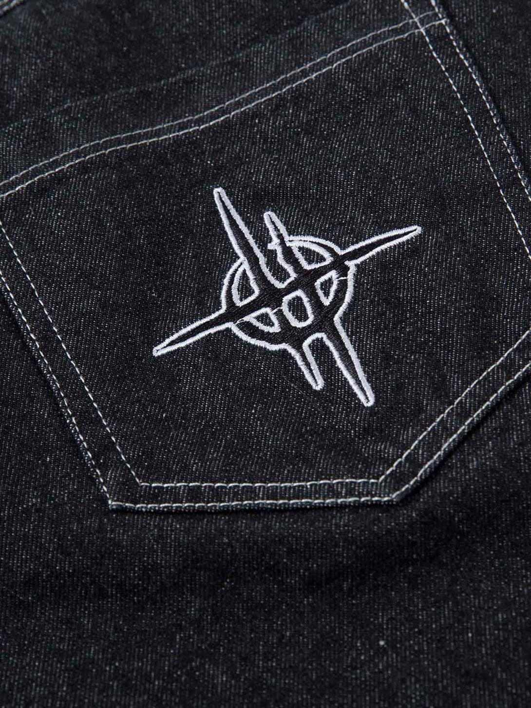 Zoomed-in view of TALISHKO's embroidered design on baggy jeans pocket, highlighting craftsmanship.
