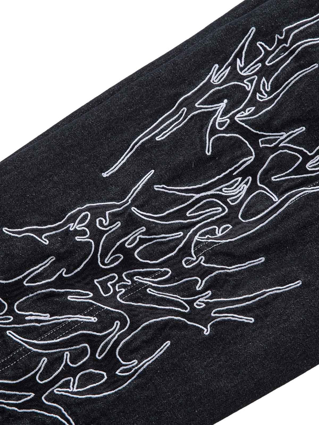 Intricate embroidery detail on TALISHKO's flame baggy jeans, showcasing bold pattern design.