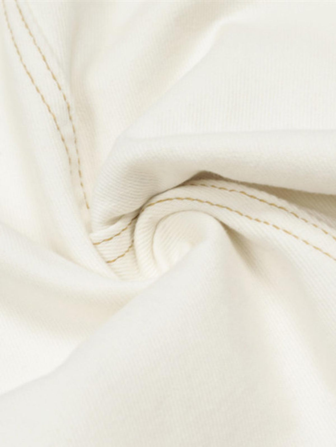 Intricate look at TALISHKO barrel jeans, showcasing white fabric texture and precise stitching.