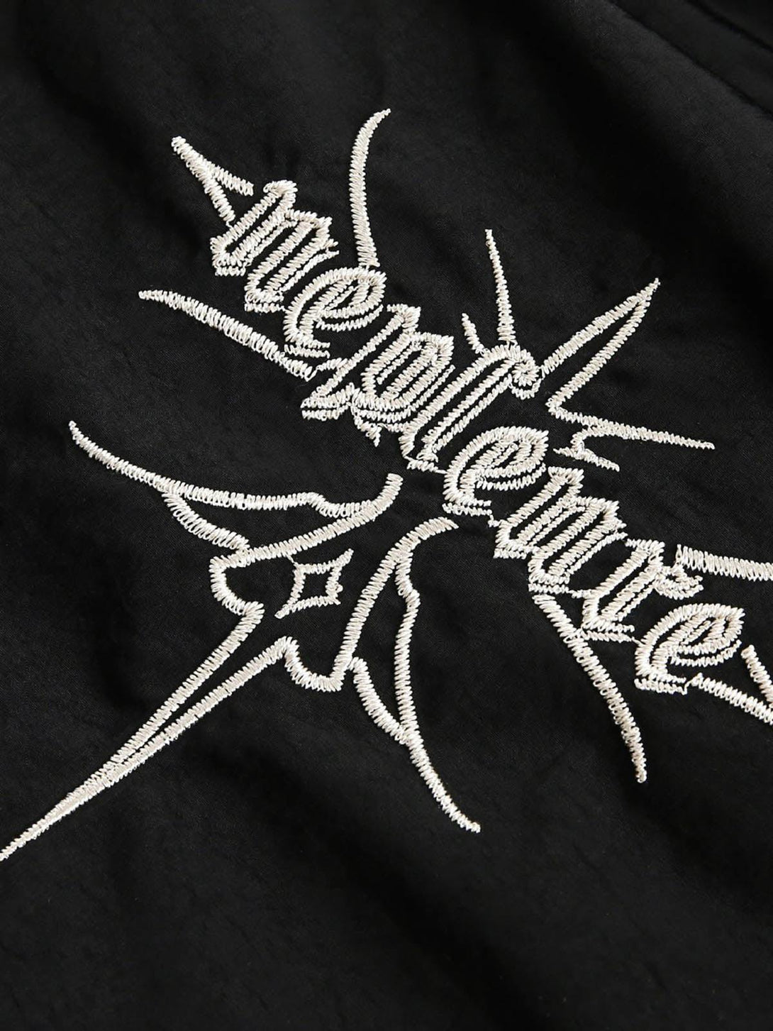 Intricate embroidery detail on TALISHKO's black quilted jacket, showcasing unique craftsmanship.