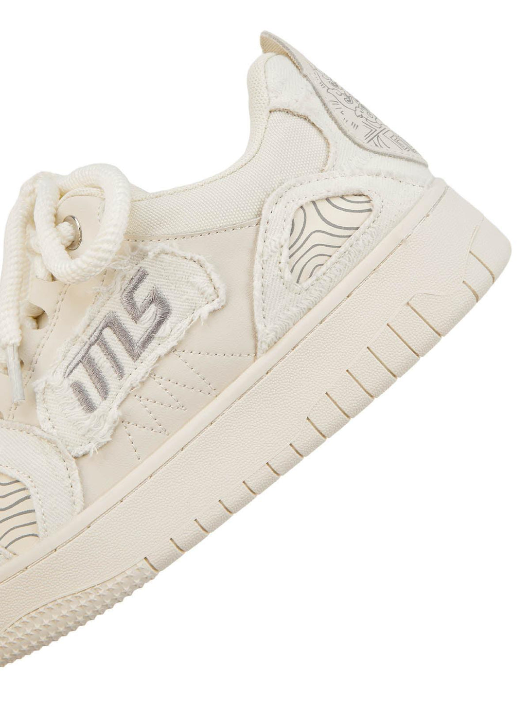 A detailed view of TALISHKO embroidered letter shoes, showcasing textured design elements.