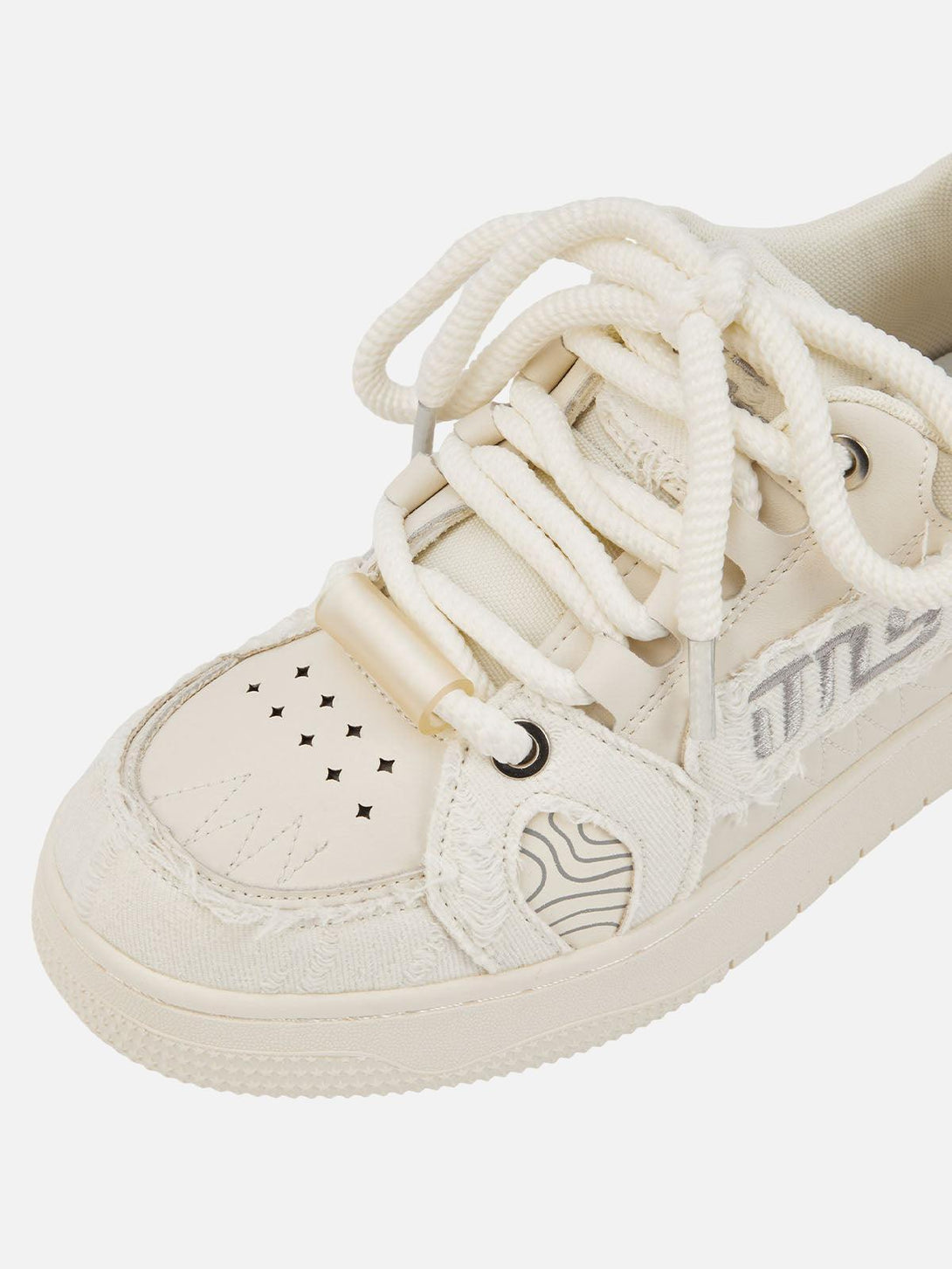 Zoomed-in view of TALISHKO shoes, highlighting intricate perforations and textured design.