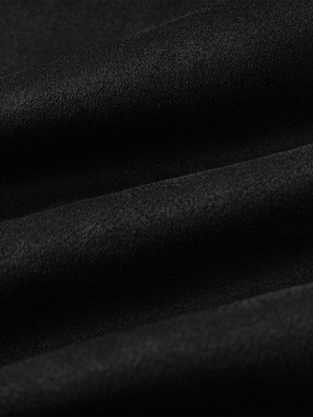A tight crop highlighting the smooth texture of TALISHKO's black oversized T-shirt fabric.