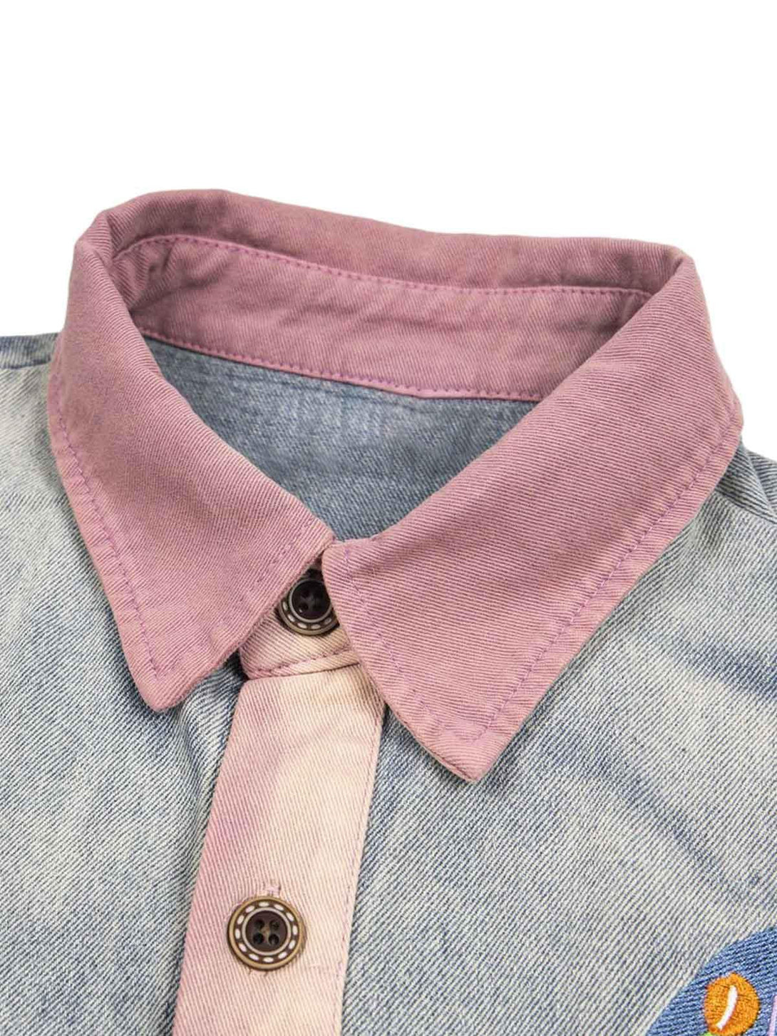 A tight crop highlighting TALISHKO's denim shirt with a contrasting pink collar and button detail.