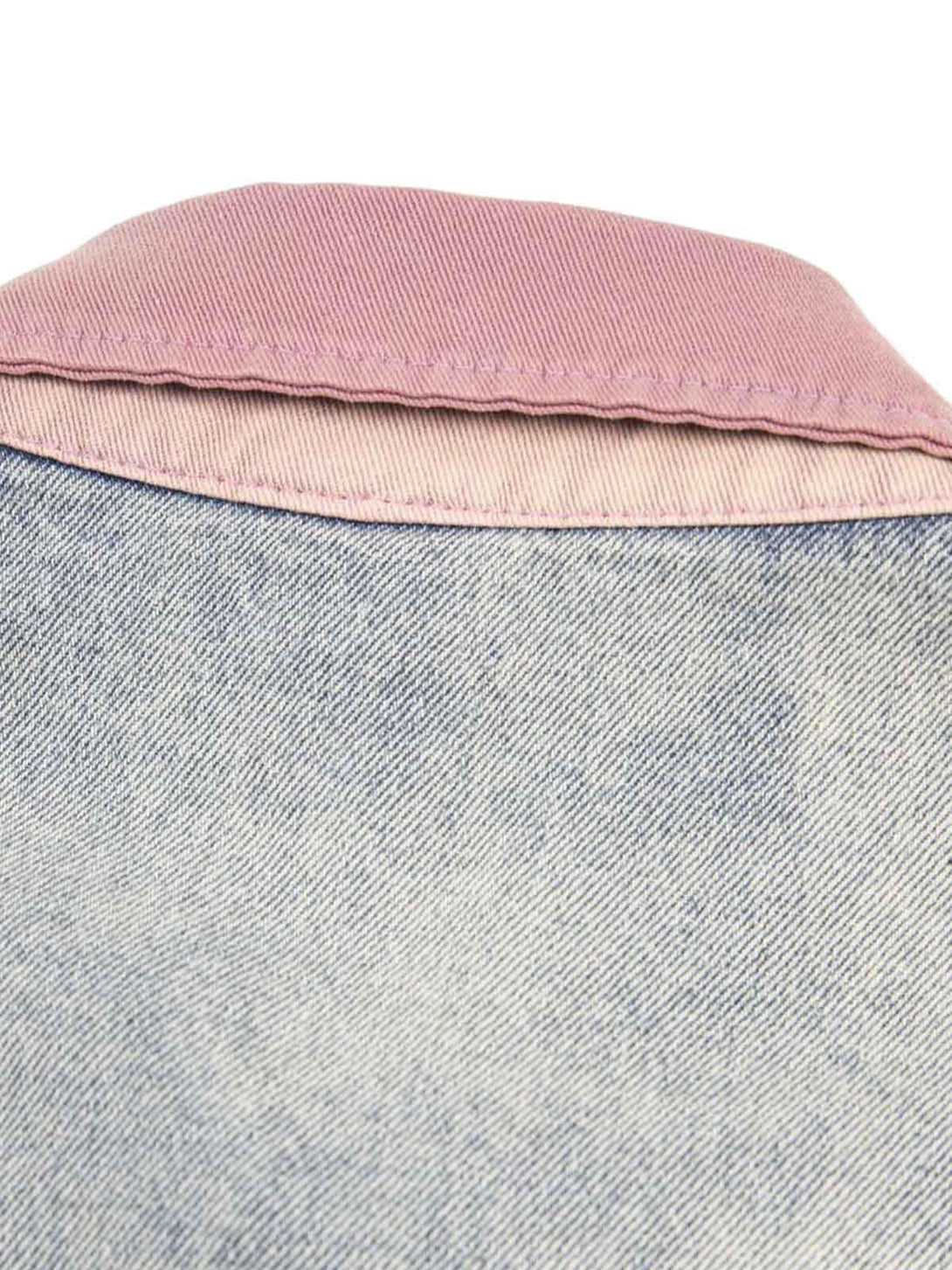 Focusing on the contrasting pink collar and denim texture of TALISHKO's shirt for a stylish touch.