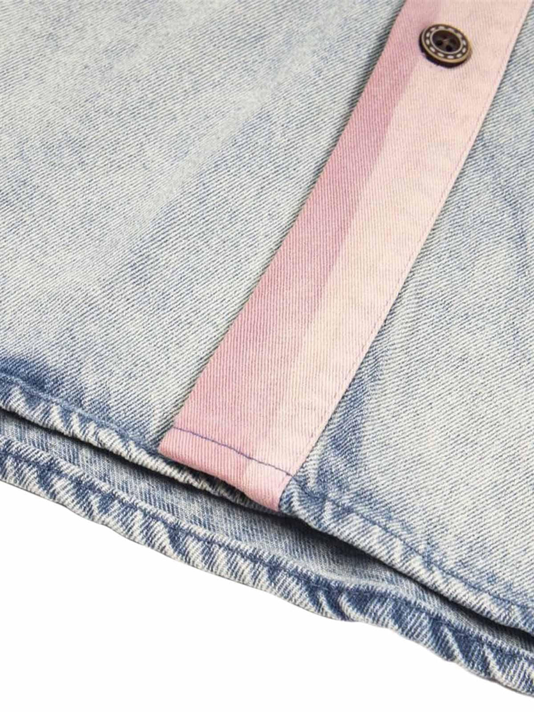 Detailed fabric and stitching on TALISHKO's denim shirt with contrasting pink accents.