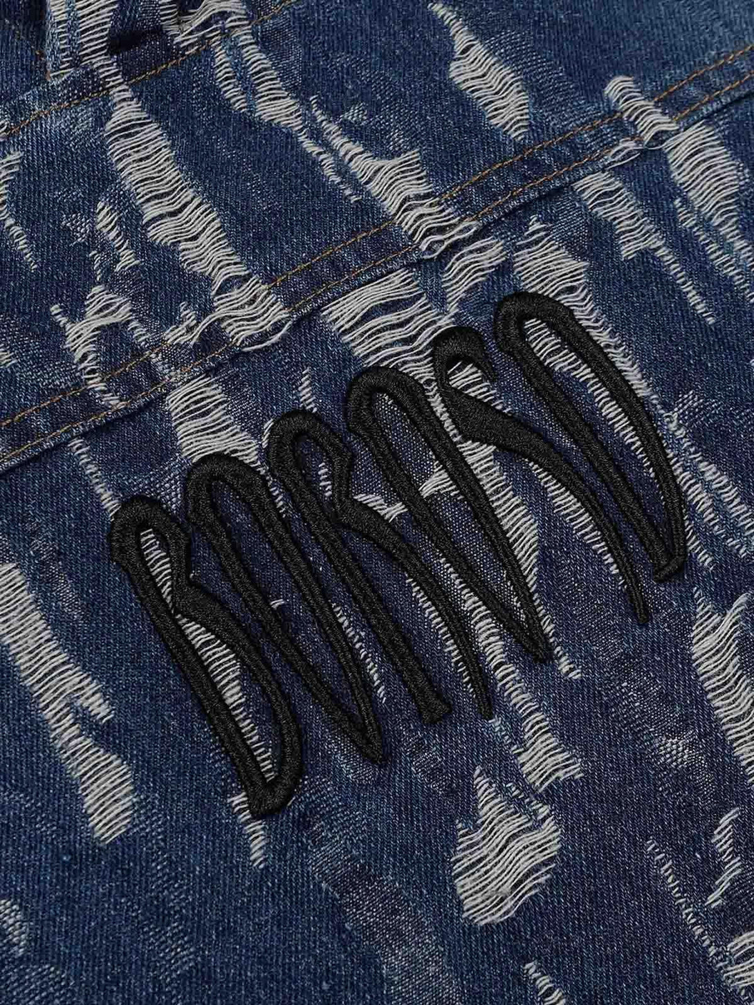 A detailed view of TALISHKO's embroidered washed denim hoodie, showcasing textured patterns.