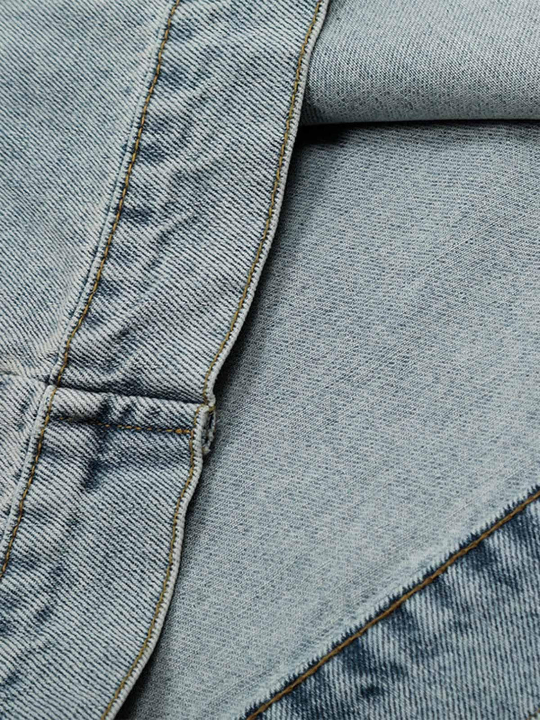 Intricate denim texture and stitching by TALISHKO, highlighting the washed and distressed fabric.
