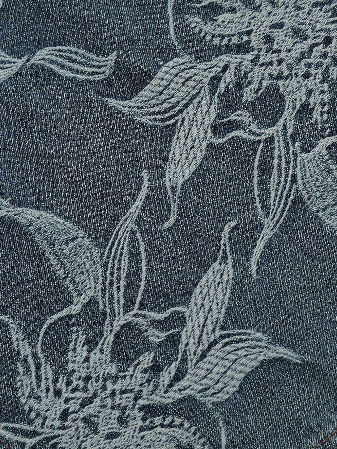 Detailed fabric and stitching of embroidered flowers on longline jorts by TALISHKO.