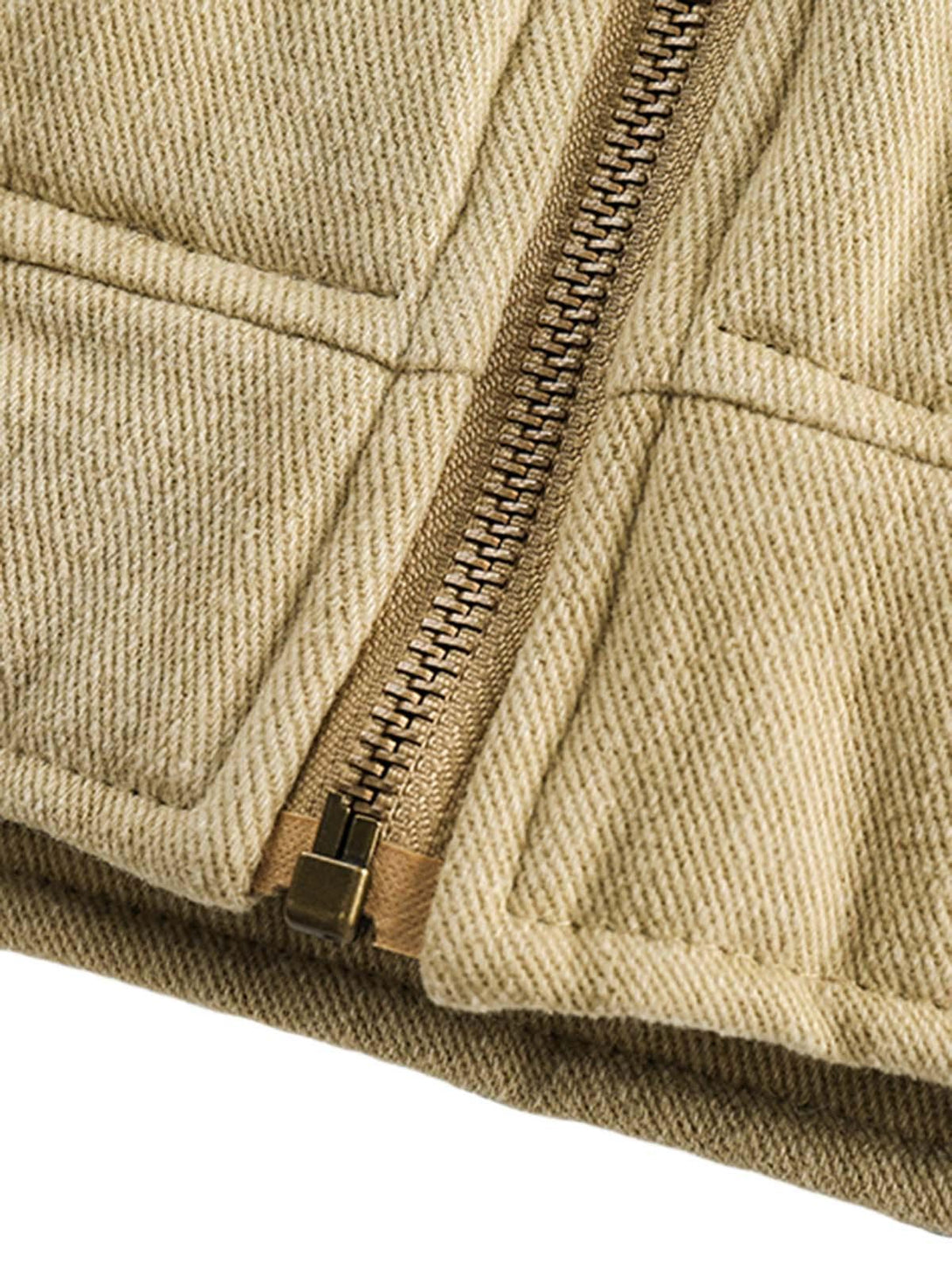Focusing on the zipper detail of a TALISHKO quilted barn jacket, showcasing textured fabric.