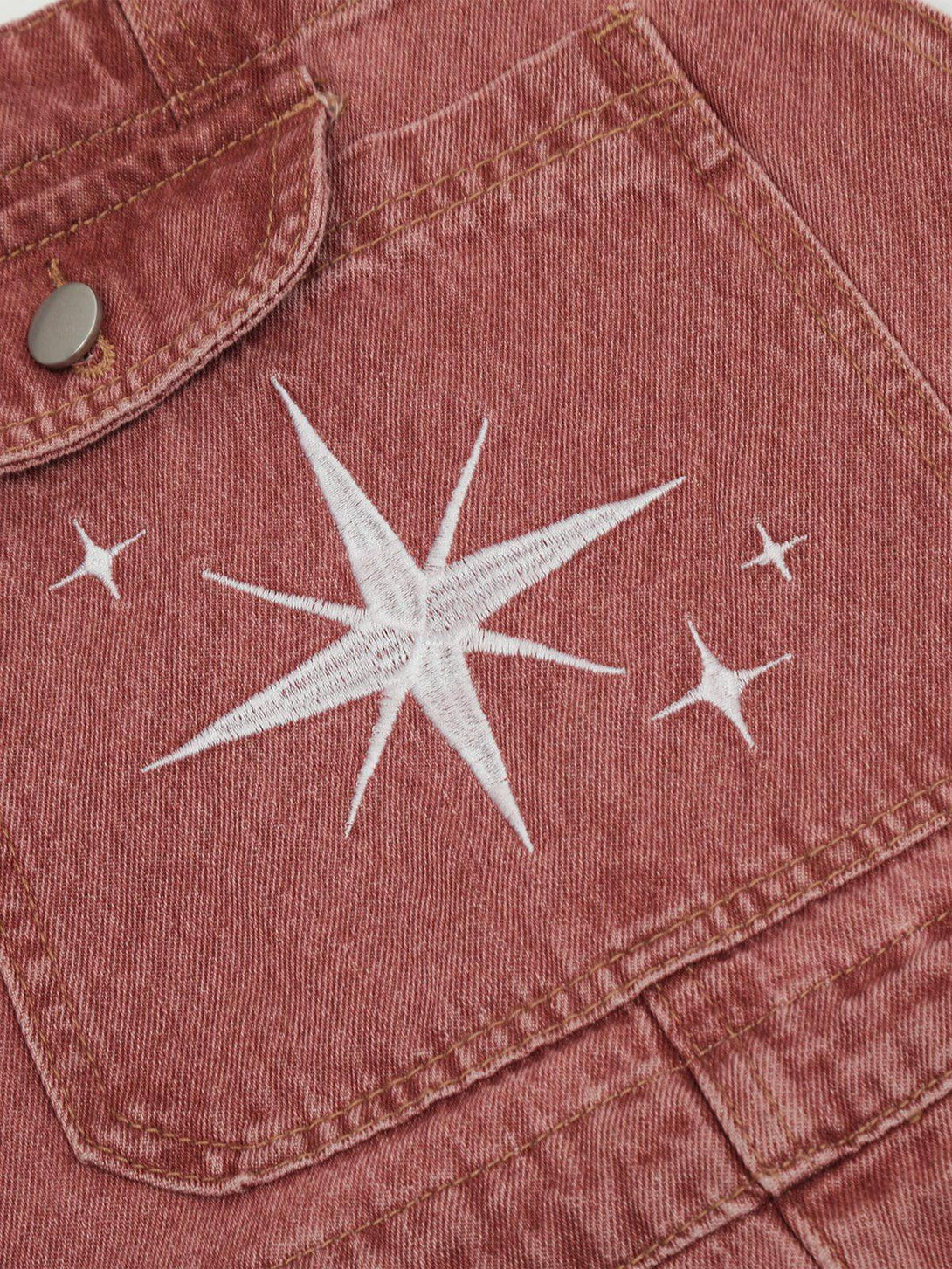 Detailed fabric and stitching of pink overalls by TALISHKO, showcasing star embroidery design.