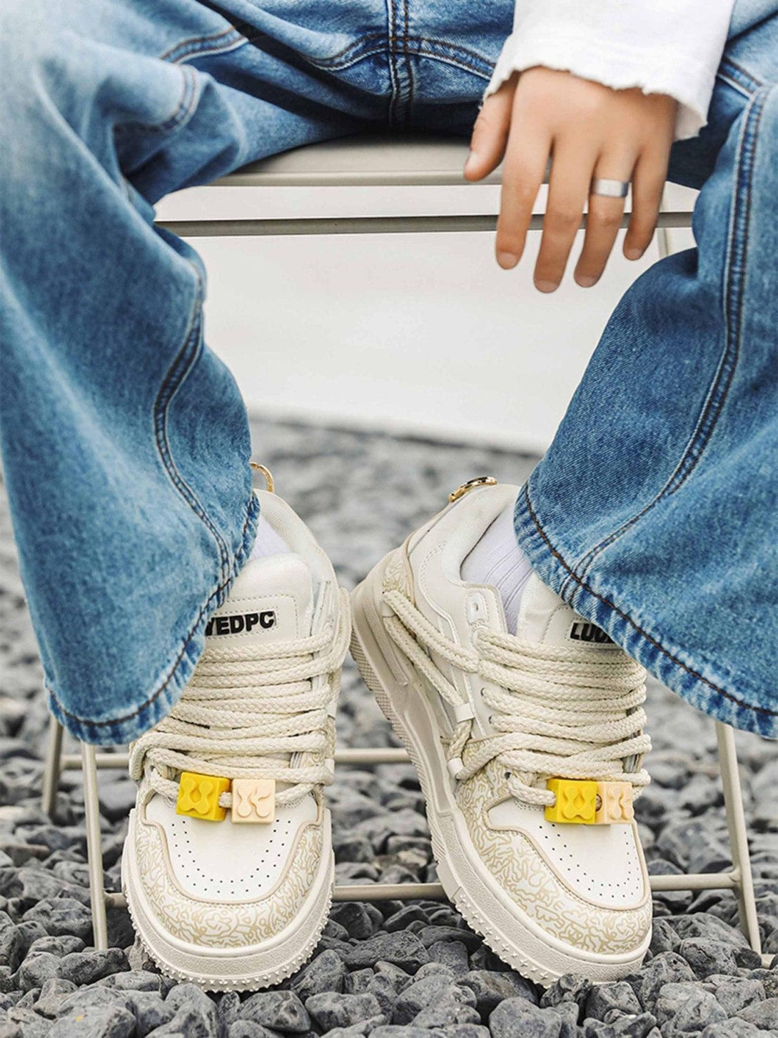 TALISHKO sneakers in cream with unique lace details, paired with relaxed denim for casual flair.