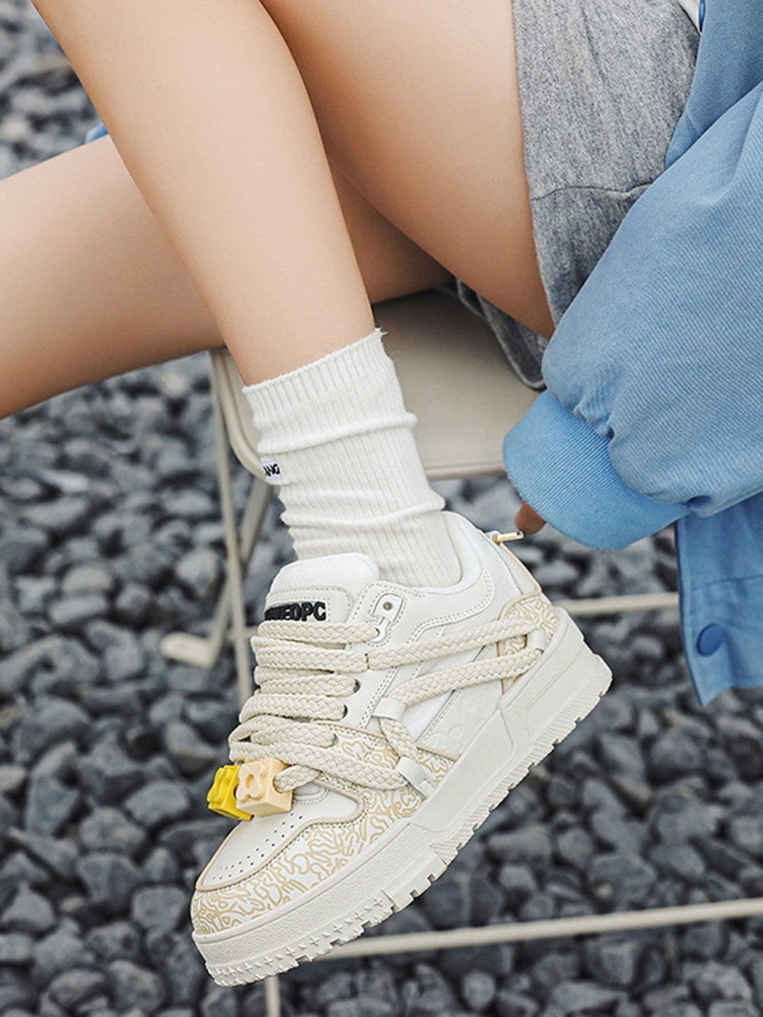 TALISHKO sneakers in cream, featuring intricate patterns and styled with casual white socks.