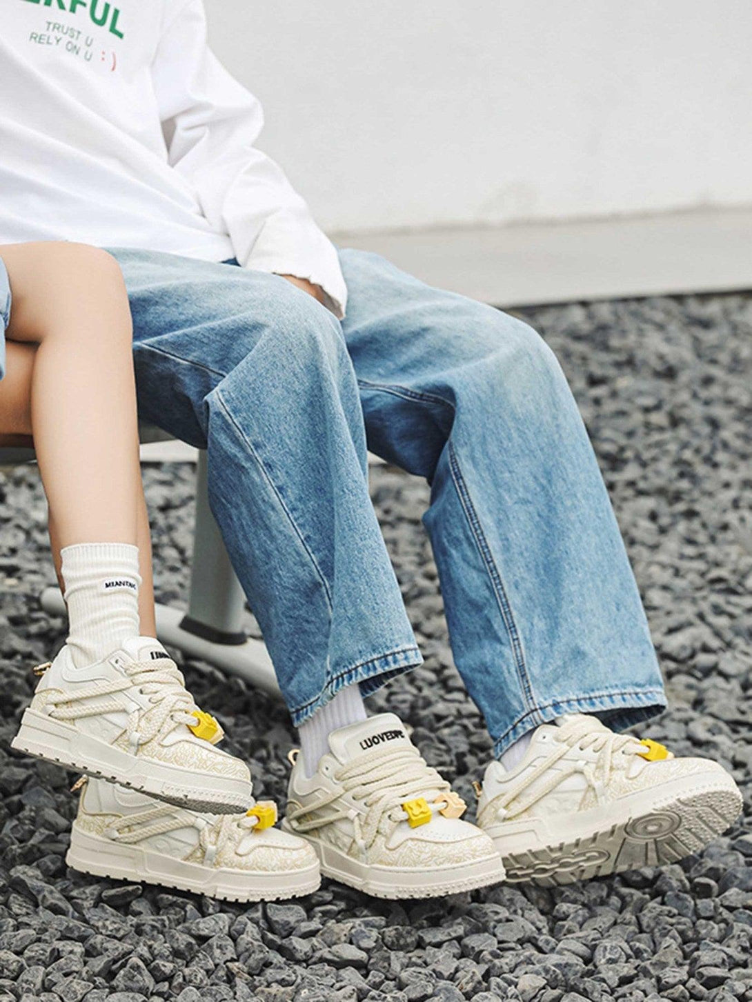 TALISHKO sneakers in cream with yellow accents, styled with casual denim for a relaxed look.