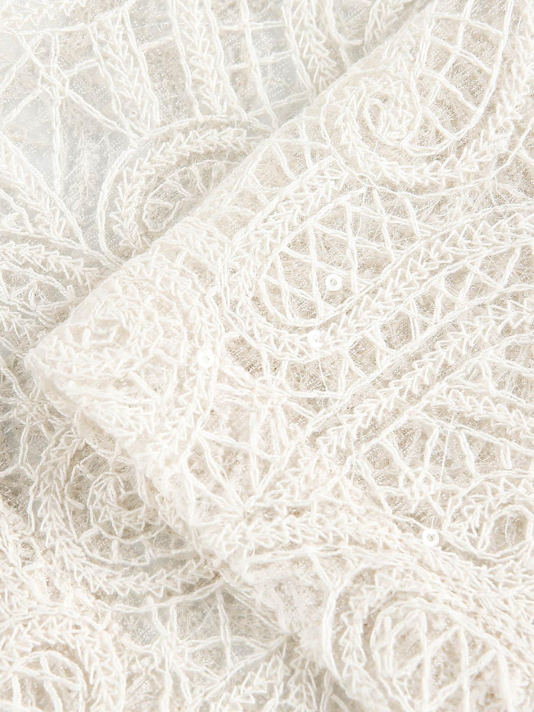 Detailed fabric and stitching of TALISHKO's floral embroidered short-sleeve shirt.