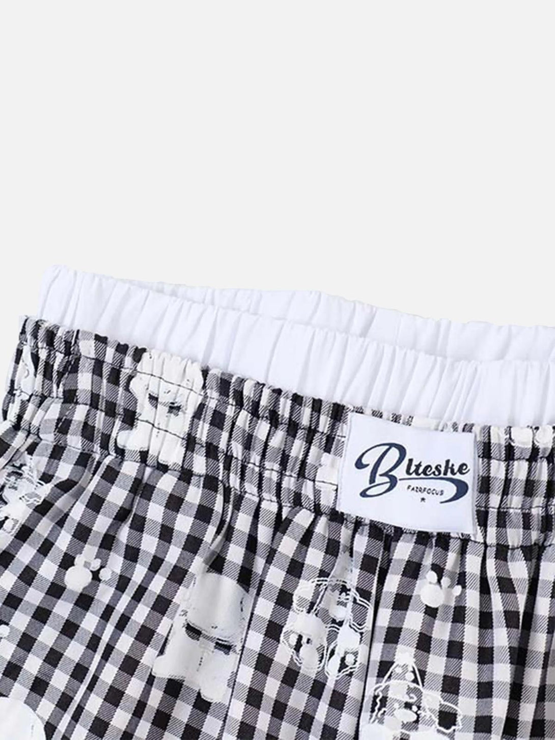 Close-up of TALISHKO plaid sweatpants featuring a playful print and elastic waistband detail.