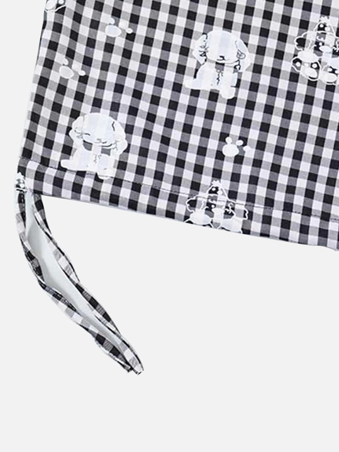 Zoomed-in texture of TALISHKO plaid fabric with playful print and tie detail.