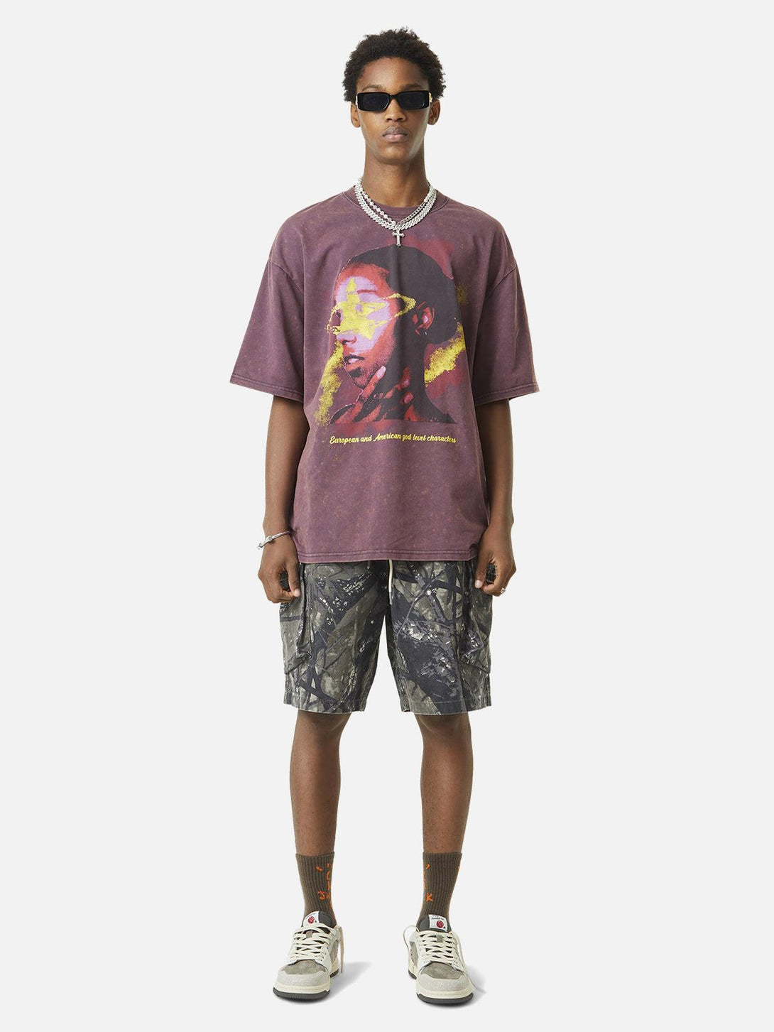 Model wearing TALISHKO t-shirt and camouflage workwear shorts, showcasing a bold street style.