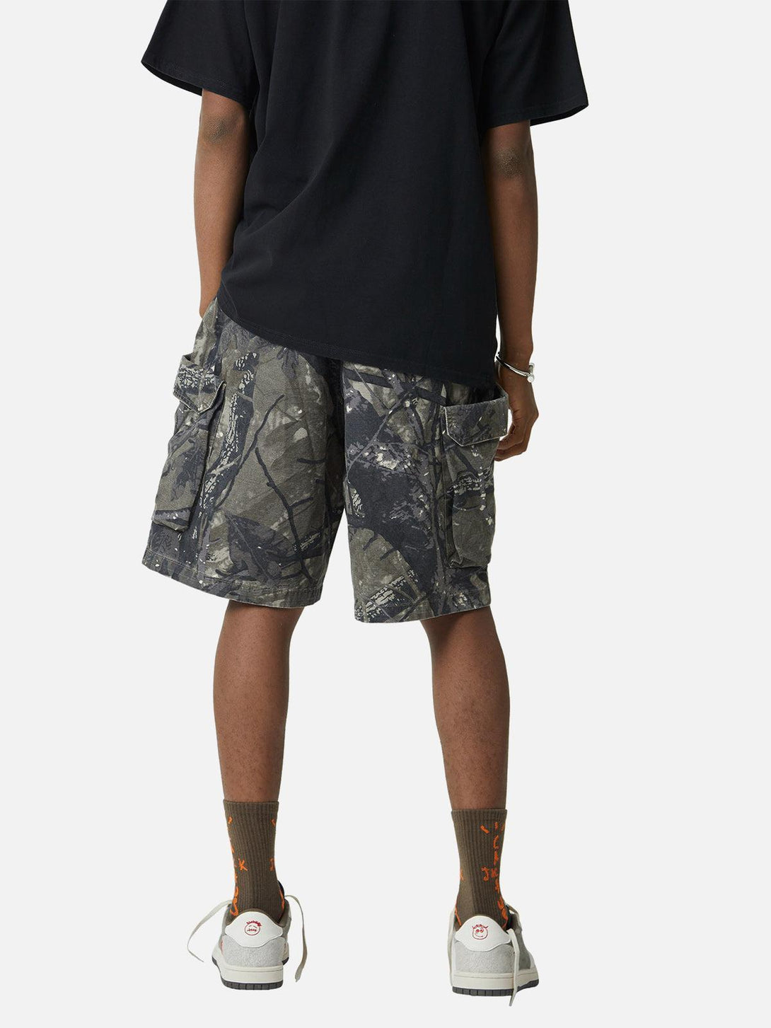Model in TALISHKO camouflage shorts, showcasing back view with practical pocket design.