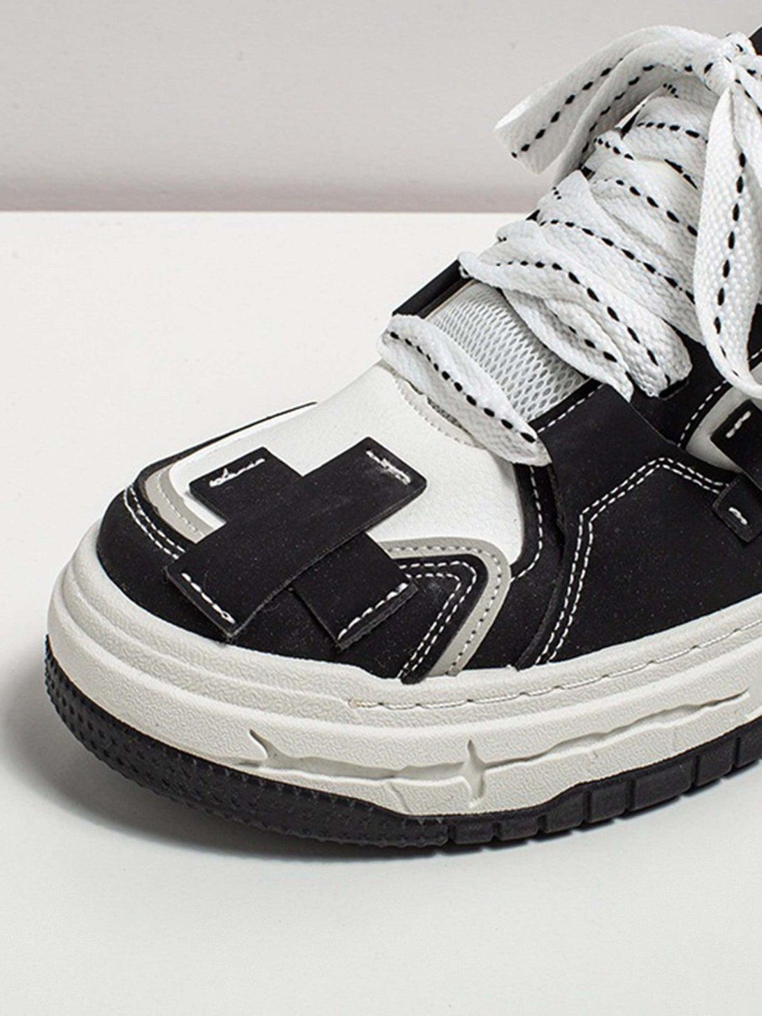 A close-up of TALISHKO thick-soled board shoes, highlighting intricate black and white details.