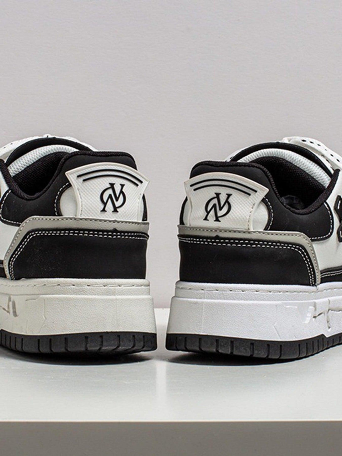 A rear view of TALISHKO thick-soled board shoes, highlighting the black and white design.