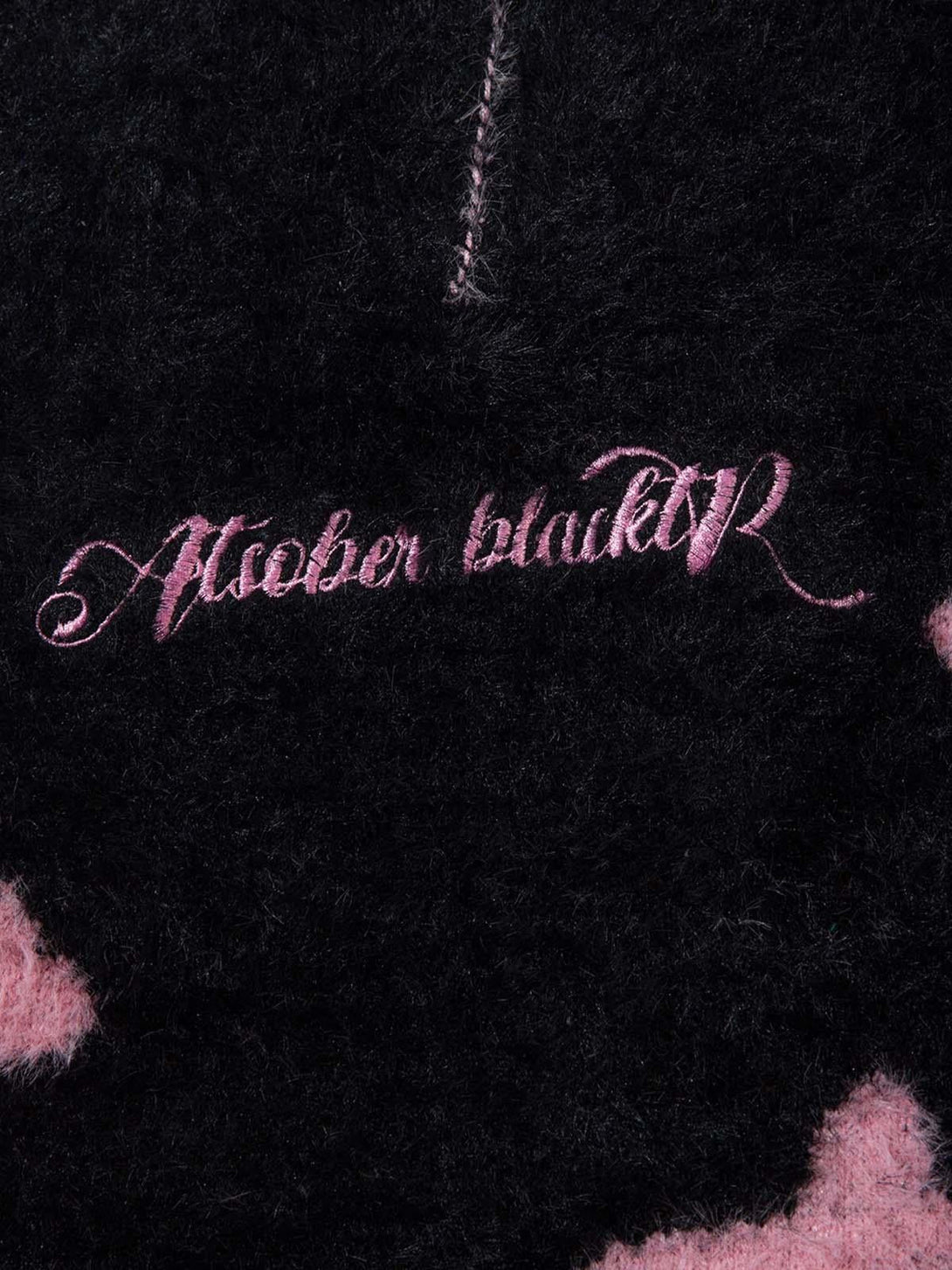 TALISHKO sweater's faux mink fabric with pink script detailing and subtle pattern.