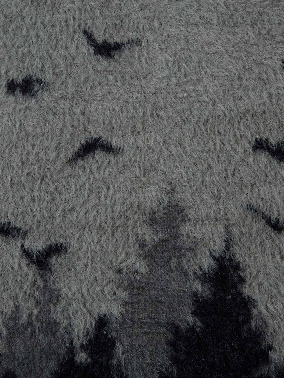 A detailed look at TALISHKO sweater fabric, highlighting the soft, fuzzy texture and bird pattern.