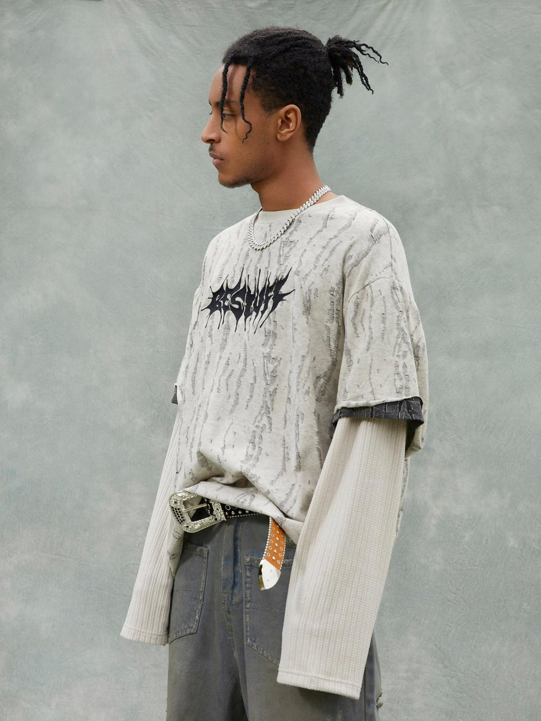 Model in TALISHKO's faux two-piece T-shirt, showcasing a distressed pattern and layered sleeves.